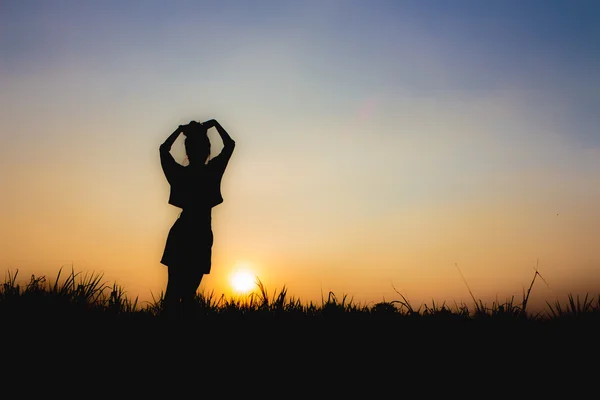 Silhouette of woman at sunset , Standing posture , near Dim atmosphere Stock Photo