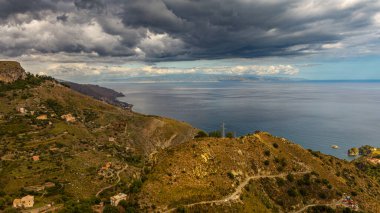Gökyüzü ve deniz arasında kara bulutlar. Sicilya Boğazı 'nın manzarası.