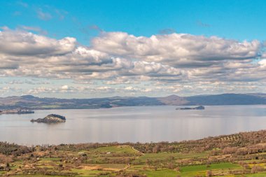 Adalar ve yuvarlanan arazilerle sakin bir manzara.