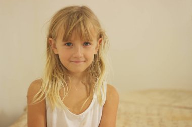 Açık bej arka planda sarışın tatlı bir kız.