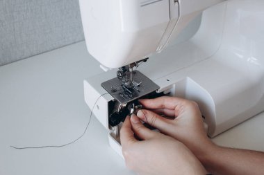 Dikiş makinesini işe hazırlıyorum. Bobbin 'i dikiş makinesine bağlıyorum. hobi ve ev konsepti, dikiş endüstrisi, tamir ve onarım