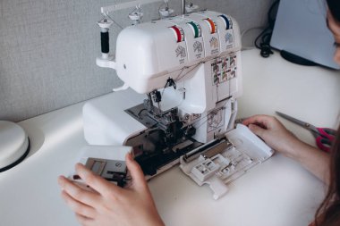 Aşırı kilitleme makinesinin içeriden görüntüsü. Çalışmaya ya da hobiye hazırlanmak için sökülmüş dikiş makinesi. Ev hobisi konsepti, dikiş dikmek. Dikiş makinesi tamir konsepti. Yan görünüm, kapat