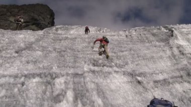 Dağcı dik bir buzlu dağ tırmanıyor.