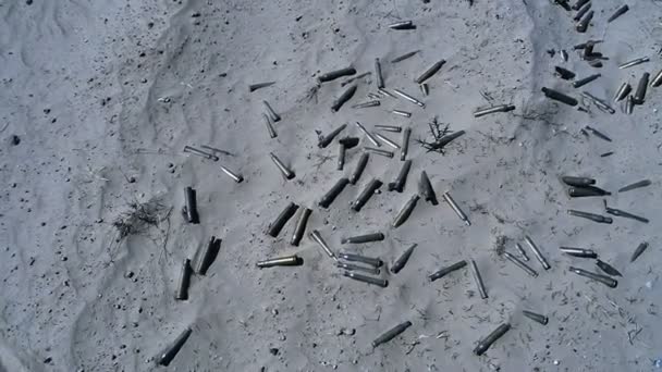 Leere Kisten von automatischen Waffen, die nach dem Kampf im Sand liegen — Stockvideo