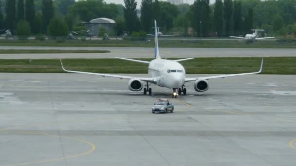 Empleados del aeropuerto descargan equipaje en el transportador desde un avión comercial — Vídeos de Stock