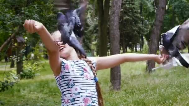Девушка играет с уличными голубями — стоковое видео