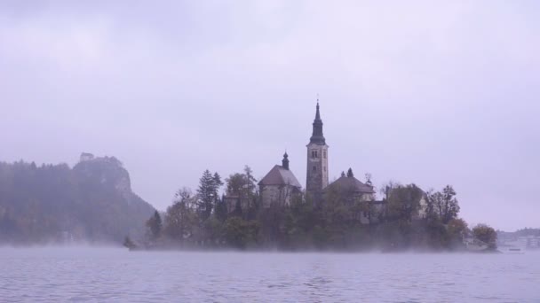Bled lake. Kerk van het eiland. Mist — Stockvideo