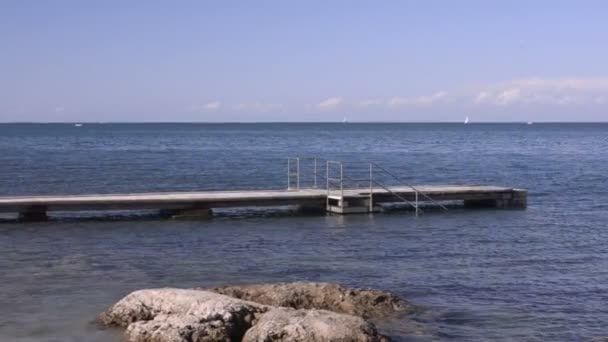 Eslovenia. Mar Mediterráneo. Pier. Un ciclista cabalga hasta el borde . — Vídeo de stock