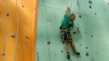 Tırmanma Duvarı açık havada. Duvardaki küçük çocuk