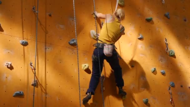 Pared de escalada al aire libre. Chica en la pared naranja — Vídeos de Stock