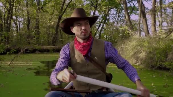 Cowboy em uma canoa flutua no rio — Vídeo de Stock