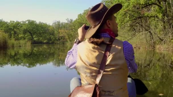 Cowboy em uma canoa flutua no rio — Vídeo de Stock