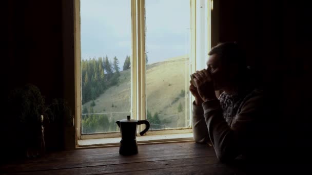Egy férfi kávét iszik az ablak mellett. — Stock videók