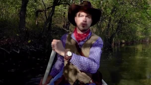 Cowboy dans un canot flotte sur la rivière — Video