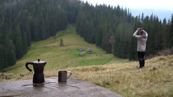 Een man in de bergen kijkt naar een prachtig landschap — Stockvideo