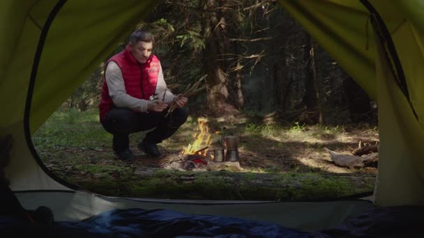 森の中の火の近くの男 — ストック動画