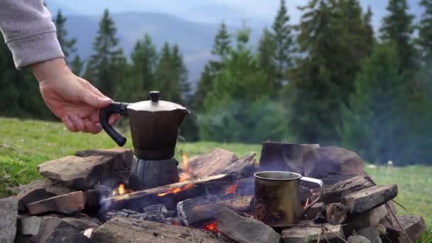 La mano de los turistas vierte café aromático en una taza de una cafetera géiser. — Vídeo de stock