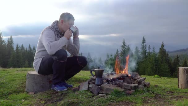 Ένας άντρας κοντά σε μια φωτιά στα βουνά — Αρχείο Βίντεο