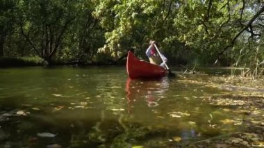 Kanodaki kovboy ormanda nehirde yüzer.