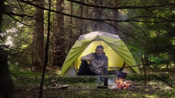 Um homem numa tenda na floresta — Vídeo de Stock