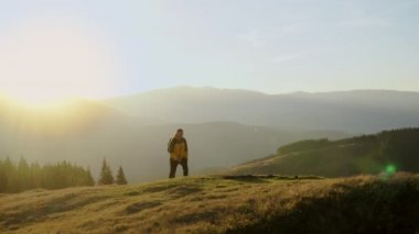 Bir adam dağlarda seyahat eder.