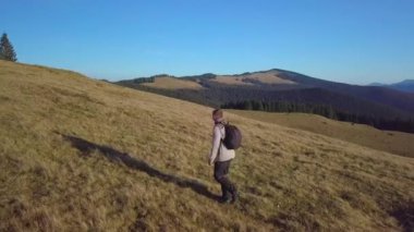 Bir adam dağlarda seyahat eder.