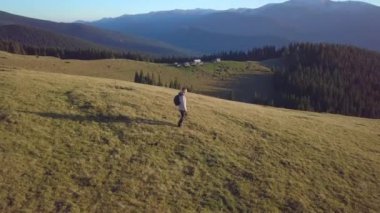 Bir adam dağlarda seyahat eder.