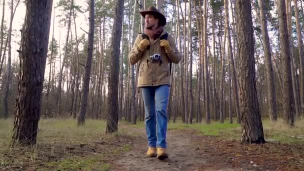 Ein Mann mit Kamera läuft auf einem Waldweg — Stockvideo