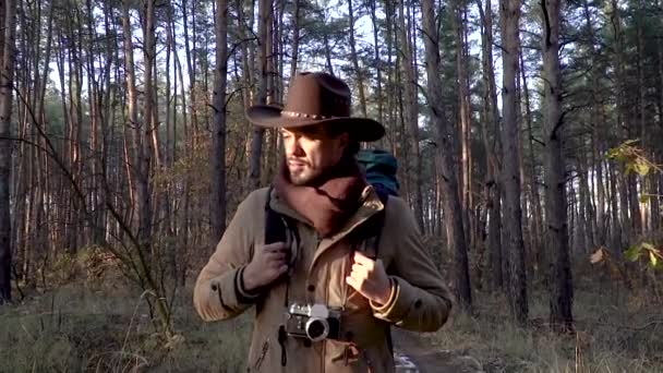 一个拿着照相机的人在森林里走在小径上 — 图库视频影像