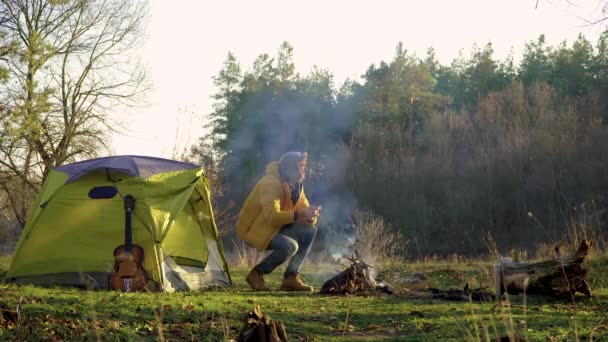 Ormanda ateşin yanında bir turist. — Stok video