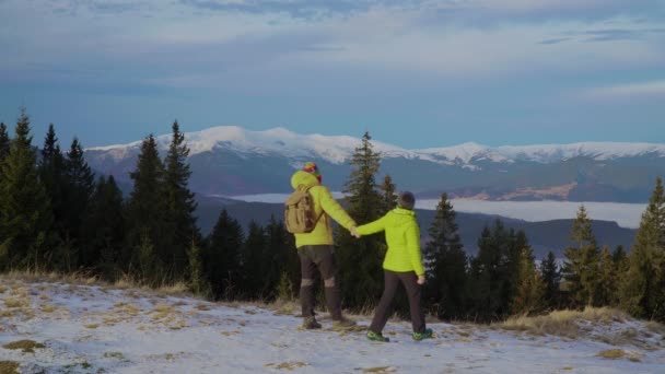 Mann und Frau sind im Winter in den Bergen unterwegs — Stockvideo