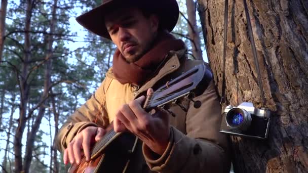 森の中でギターを持った帽子のバックパッカー — ストック動画