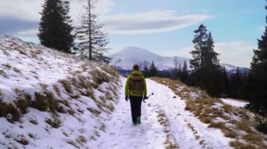 Bir kadın kışın dağlarda seyahat eder.