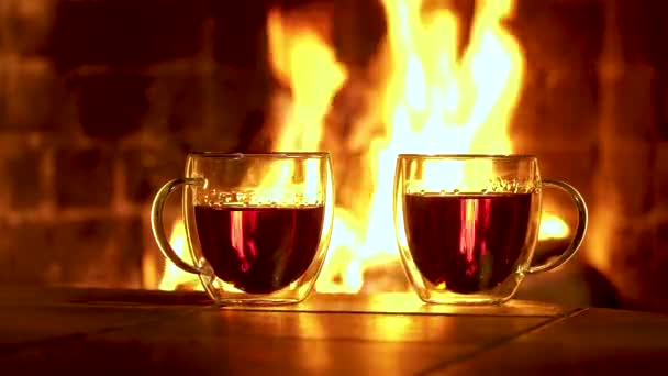Ποτήρια γυάλινα με τσάι στο φόντο του τζακιού — Αρχείο Βίντεο