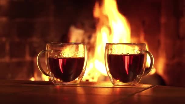Glass cups with tea on the background of the fireplace — Stock Video