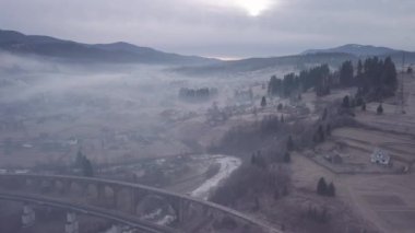 Karpat Dağları 'ndaki köy ve demiryolu köprüsünün üzerinden uçmak