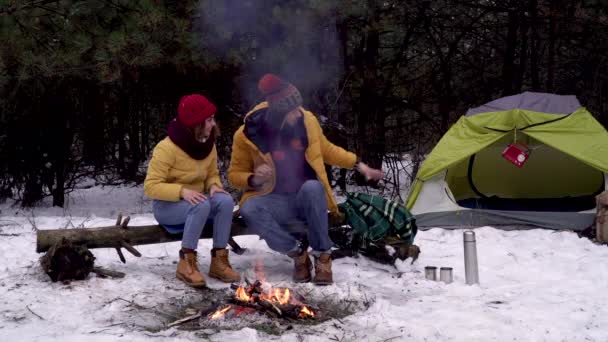 Le gars abrite une fille avec une couverture dans les bois en hiver — Video