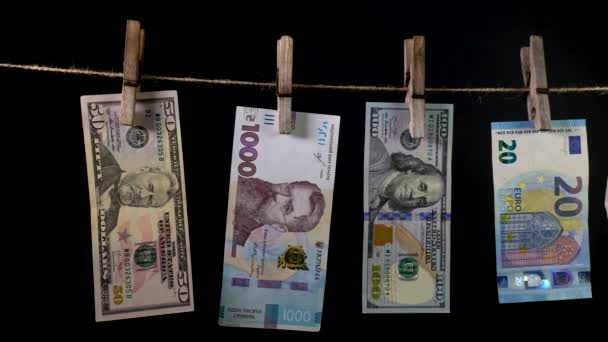 Billetes de diferentes países se secan en una cuerda de pinza — Vídeo de stock