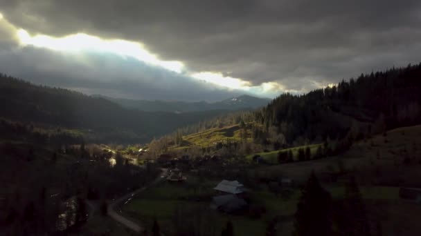 Vista aérea de nubes de tormenta y un pueblo en las montañas — Vídeo de stock