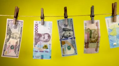 Farklı ülkelerin banknotları mandal ipinde kurur.