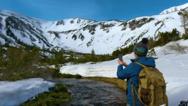 若い女性は山の中で冬の風景の写真を撮る — ストック動画