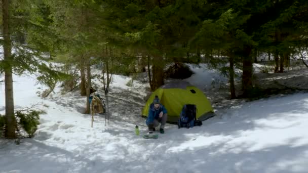 Mujer preparando comida cerca de la tienda en el bosque de invierno — Vídeos de Stock