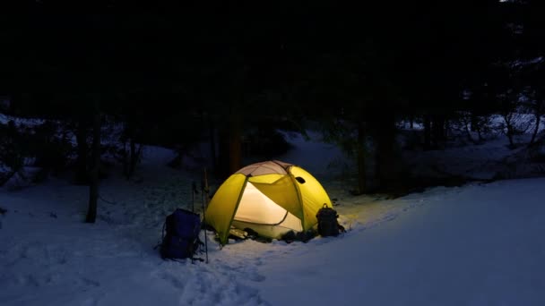 Kış ormanında sarı ışıklı çadır — Stok video