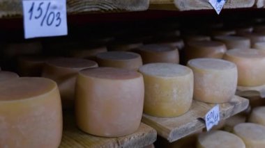 Peynir fabrikasının mahzenindeki raflarda olgunlaşan parmesan peynirlerine bakın.