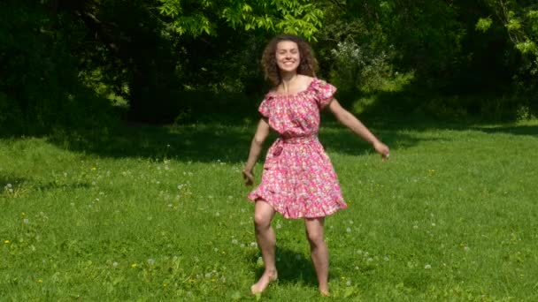 La fille en robe danse sur la pelouse — Video