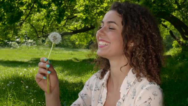 Jovem menina retrato sopra dente bola de sopro flor em um parque de primavera — Vídeo de Stock