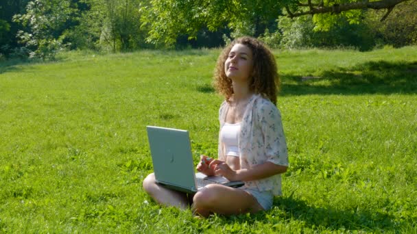 Vacker flicka student som arbetar på laptop i parken — Stockvideo