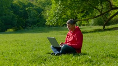 Yaz ormanlarında dizüstü bilgisayarda çalışan adam.