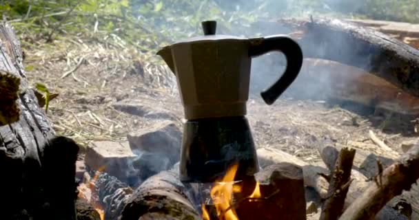 Het koffiezetapparaat bereidt koffie boven het vuur — Stockvideo