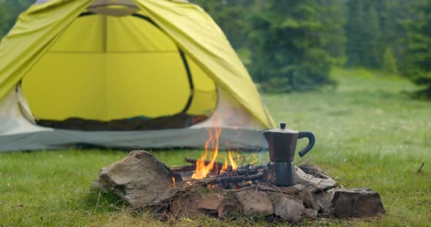 Dzbanek do kawy przy kominku i namiocie w leśnej polanie — Wideo stockowe